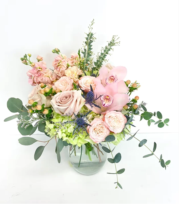 Mother's Day bouquet with pink roses, orchids, and eucalyptus in a glass vase